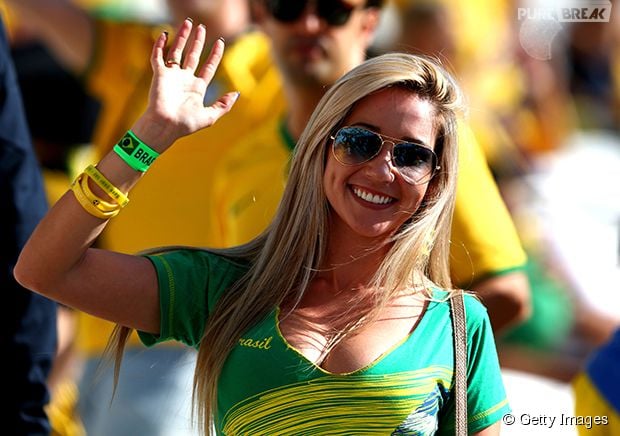 Torcedora do Brasil acena para a câmera durante o jogo