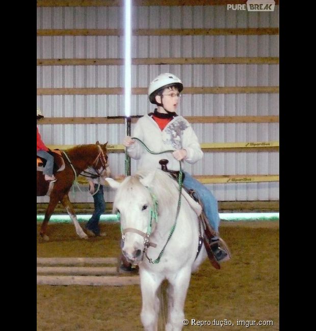 Garotinho em cima do cavalo com um sabre de luz