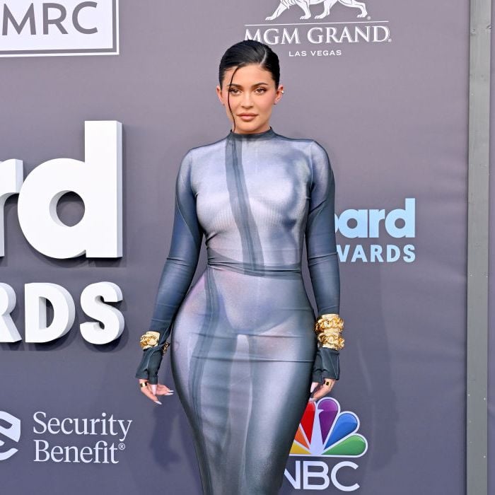 Kylie Jenner investiu em um vestido justo em um tom cinza frio, combinando com pulseira de ouro e saltos todos da Balmain, no Billboard Music Awards 2022