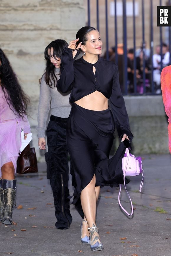 Rosalía em seu conjuntinho preto com bolsa lilás na Paris Fashion Week 2023