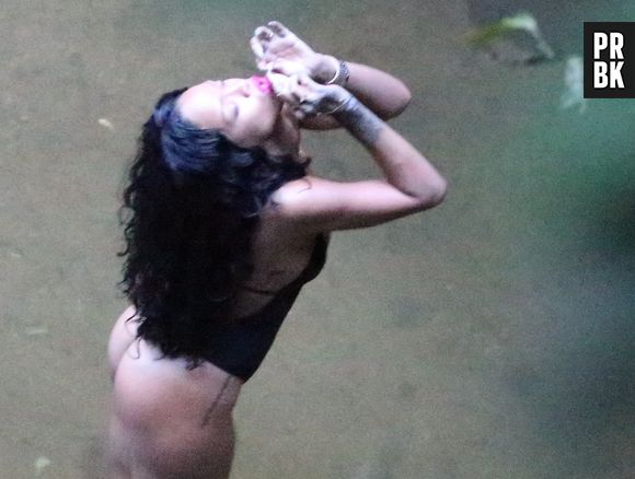 Com cigarro suspeito nas mãos, Rihanna curtiu uma das cachoeiras cariocas, durante sua passagem pelo Brasil, em 2014