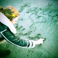 Karlie Kloss grava na areia seu nome e da amiga Taylor Swift