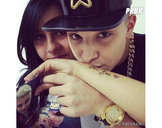 Mc Gui dá beijo em tatuagem de fã em sua homenagem