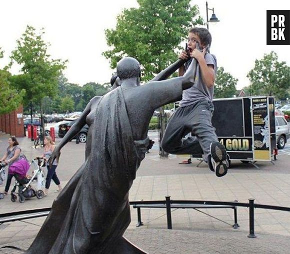 O que será que esse moleque fez pra estátua agarrar ele?