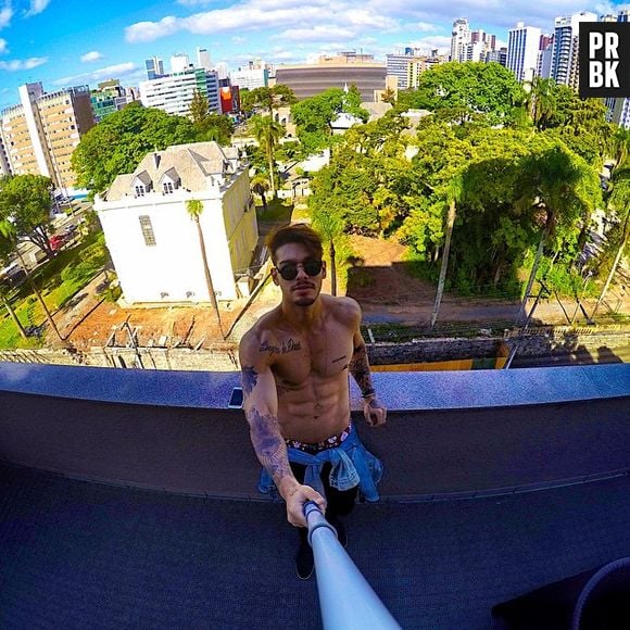 Lucas Lucco relaxa em sua varanda com o seu "pau de selfie". Sem camisa, é claro