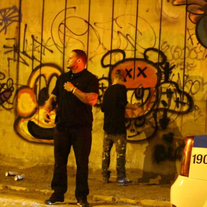 Seguranças &quot;cuidam&quot; para que ninguém perturbe Justin Bieber enquanto ele grafita muro
