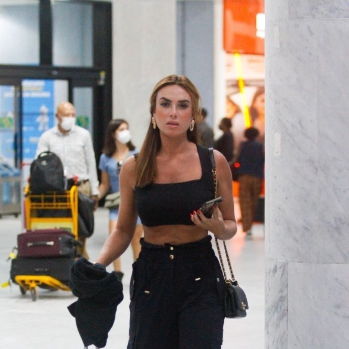 Nicole Bahls adota look all black e salto alto em aeroporto