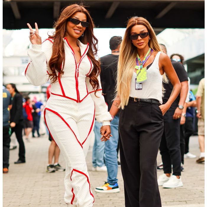 Ludmilla perfeita com macacão branco e vermelho ao lado de Brunna Gonçalves de calça e blusinha no GP de F1