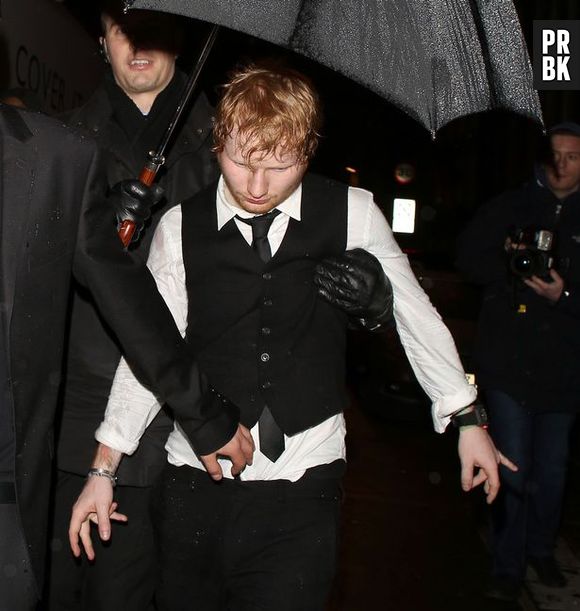 Seguranças ajudam Ed Sheeran a sair da festa do BRIT Awards 2015