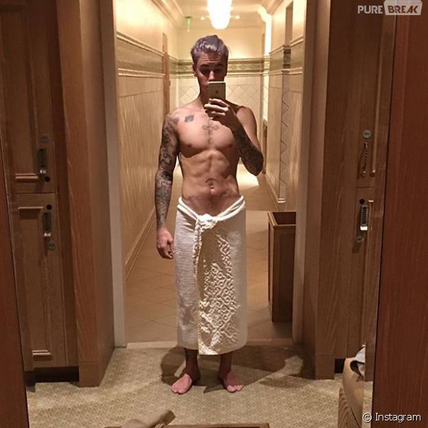 De toalha, Justin Bieber exibe seu cabelo platinado e com tons de roxo