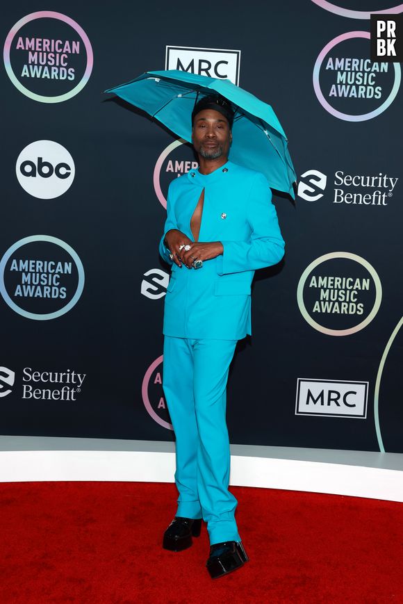 Billy Porter  usou um chapéu de chuva combinando com seu terno azul, ambos acervos da marca Botter