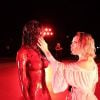 Doja Cat posou ao lado de sua estátua coberta de sangue