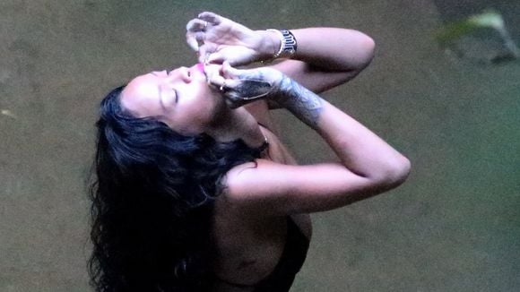 Rihanna, no Brasil, é flagrada de maiô fio dental e fumando cigarrinho suspeito