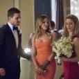  Felicity (Emily Bett Rickards) pega o buqu&ecirc; da noiva e mostra para Oliver (Stephen Amell) e Laurel (Katie Cassidy) em "Arrow" 