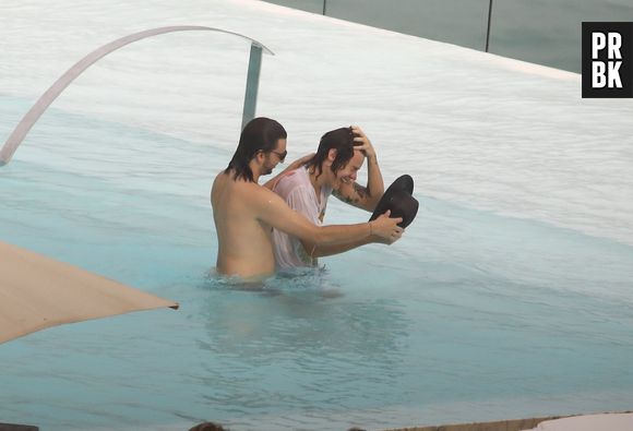 Mesmo na piscina, Harry Styles não abriu mão do chapéu