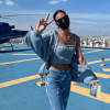 Bruna Marquezine forma look estilo kidcore: cropped, jeans, cardigã e um tênis flat branco.