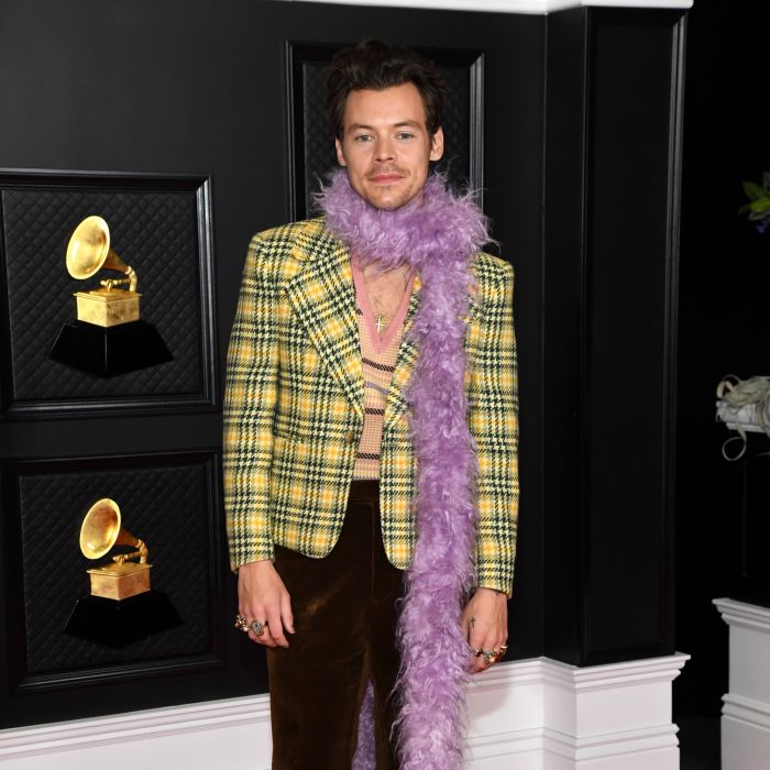 Contrariando o público, Harry Styles apareceu com dois ternos no Grammy Awards 2021. Um deles preto e de couro e outro um blazer xadrez amarelo. Os dois foram complementados com encharpes de plumas coloridas
