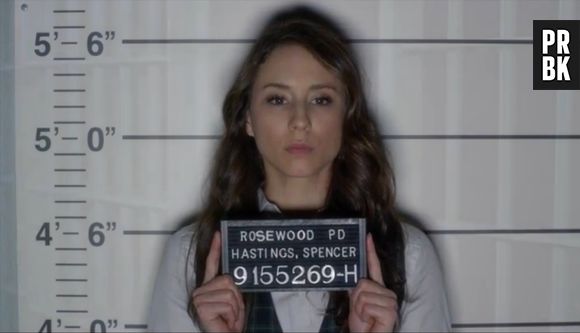 Em "Pretty Little Liars", Spencer (Troian Bellisario) posa para ser fichada com seu nome
