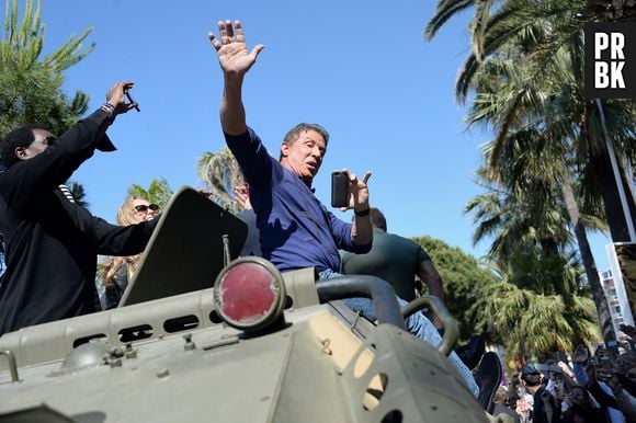 Sylvester Stallone acena para os fãs ao chegar em um tanque de guerra para divulgar "Os Mercenários 3", em Cannes