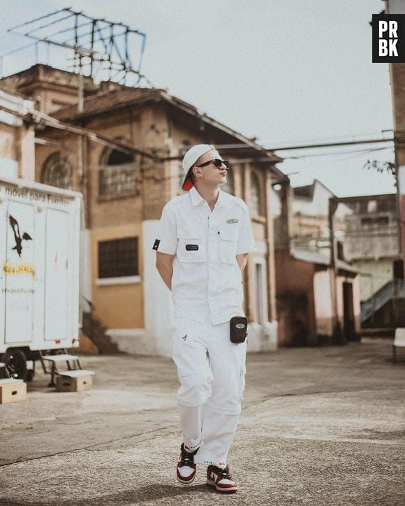 Leo Picon com look monocromático branco, composto por calça cargo e acessórios