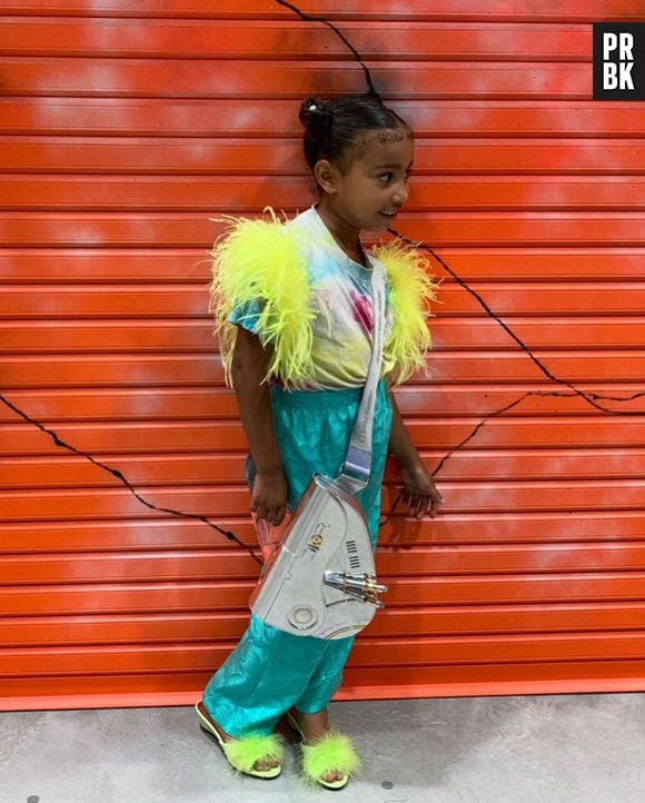 North West adota plumas neon em sua t-shirt e sandália