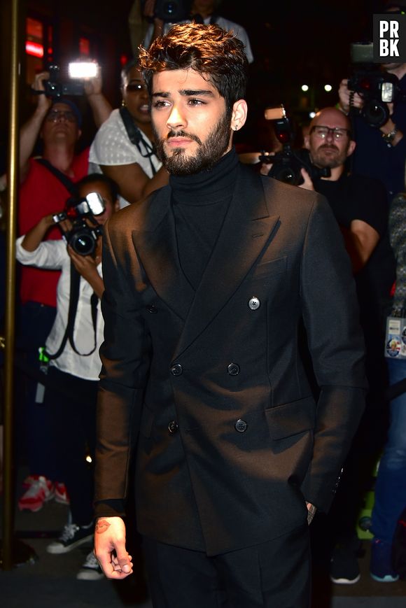 Zayn Malik em um look todo preto, composto por gola rolê e blazer