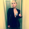 Miley Cyrus afasta a parte do blazer que cobre os seios, mas tampa mamilos para poder postar no Instagram