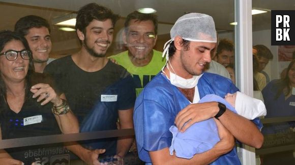 Rodrigo Simas e Bruno Gissoni veêm o sobrinho recém-nascido atravês do vidro, no colo de Felipe Simas