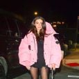 Charli  XCX combina look com meia-calça e jaqueta puffer pink 