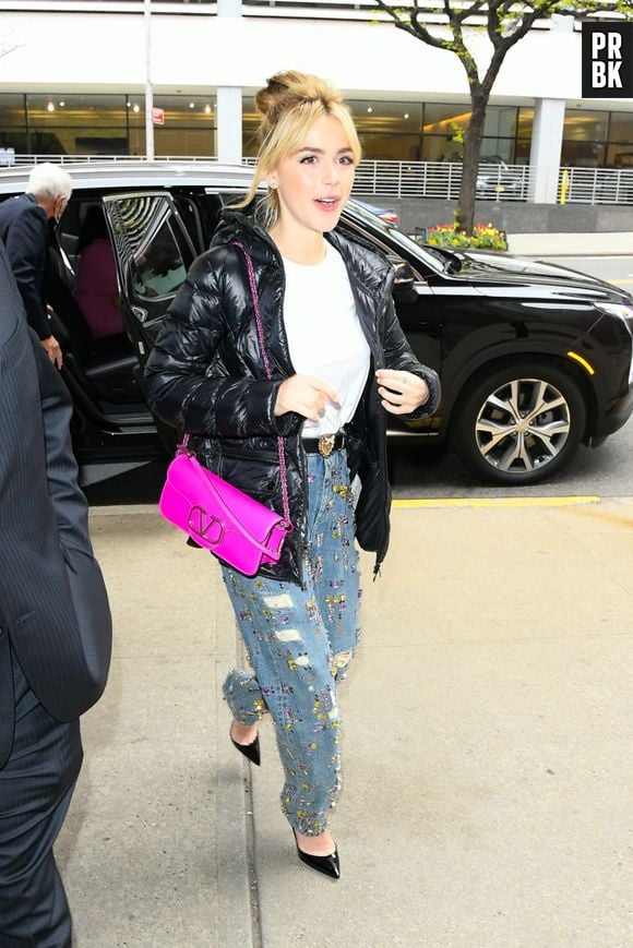 Kiernan Shipka, a "Sabrina", combina look casual chic com jaqueta puffer e bolsa Valentino pink