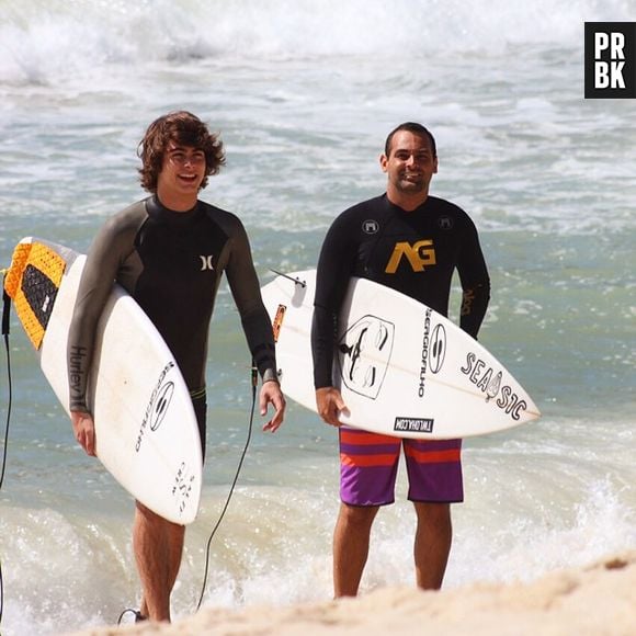 Rafael Vitti se diverte na praia com sua prancha de surf, durante folga das gravações de "Malhação"