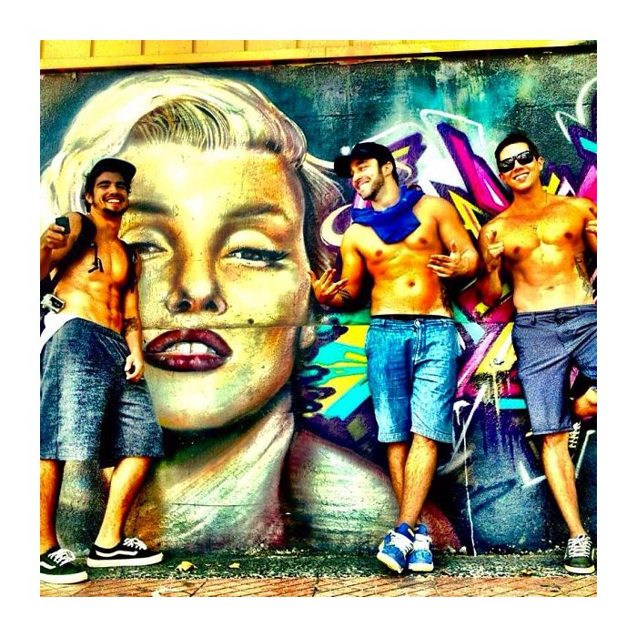  Caio Castro sem camisa posa na frente de um grafite da Marilyn Monroe 
