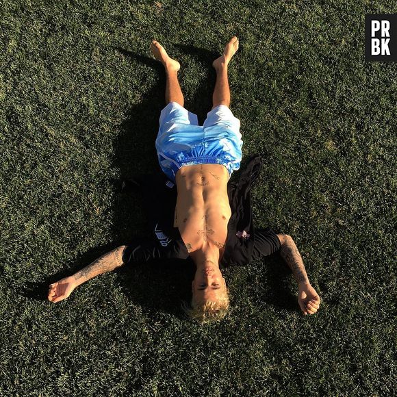 Justin Bieber relaxando e mostrando o corpão no meio da grama, que vidão!