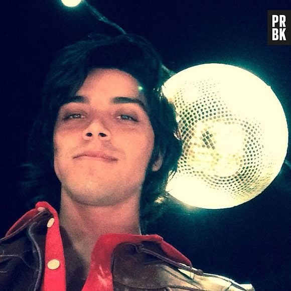 Rodrigo Simas exibe seu novo look com um globo de espelhos atrás no set de "Boogie Oogie"