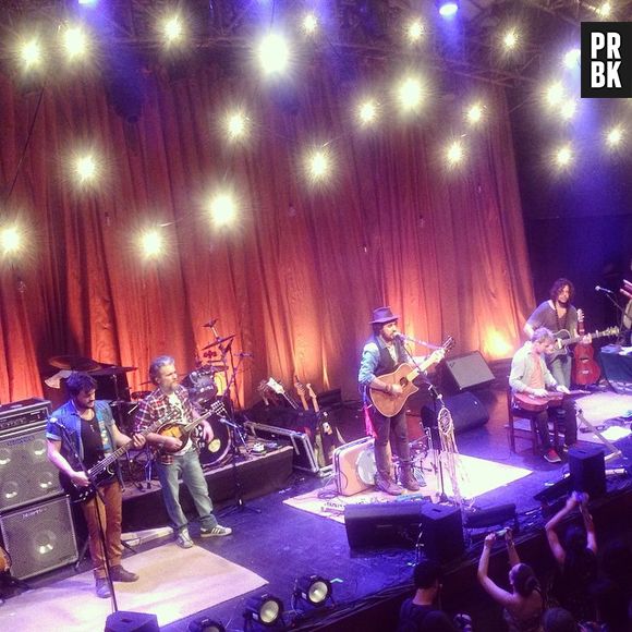 O palco no show da Suricato era decorado com lâmpadas e uma iluminação vermelha